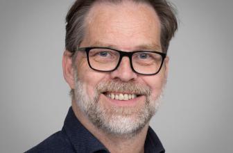 Maður með skegg og svört gleraugu.