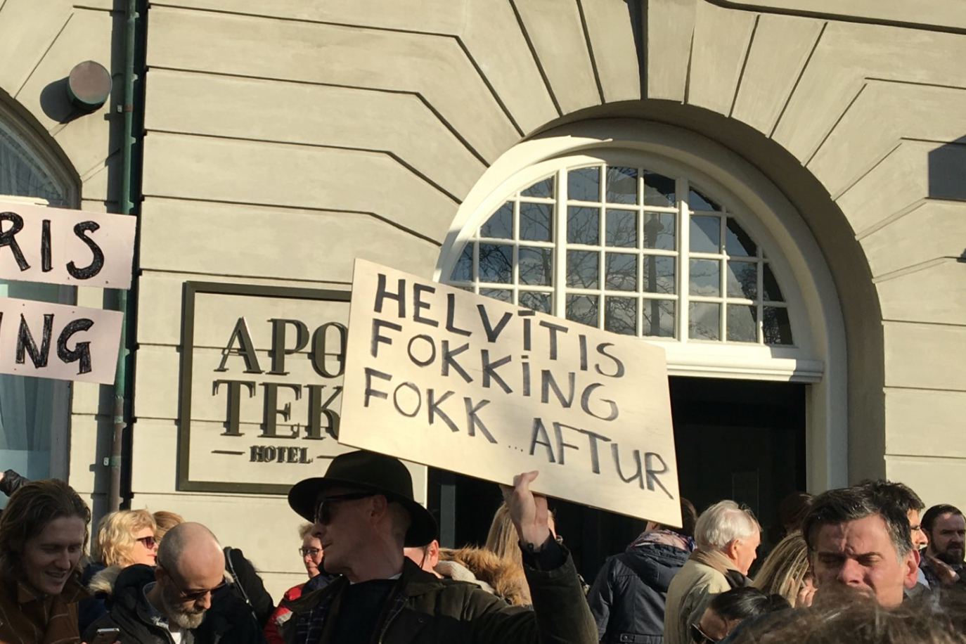 Hópur mótmælenda. Maður með skilti sem á stendur "Helvítis fokking fokk".
