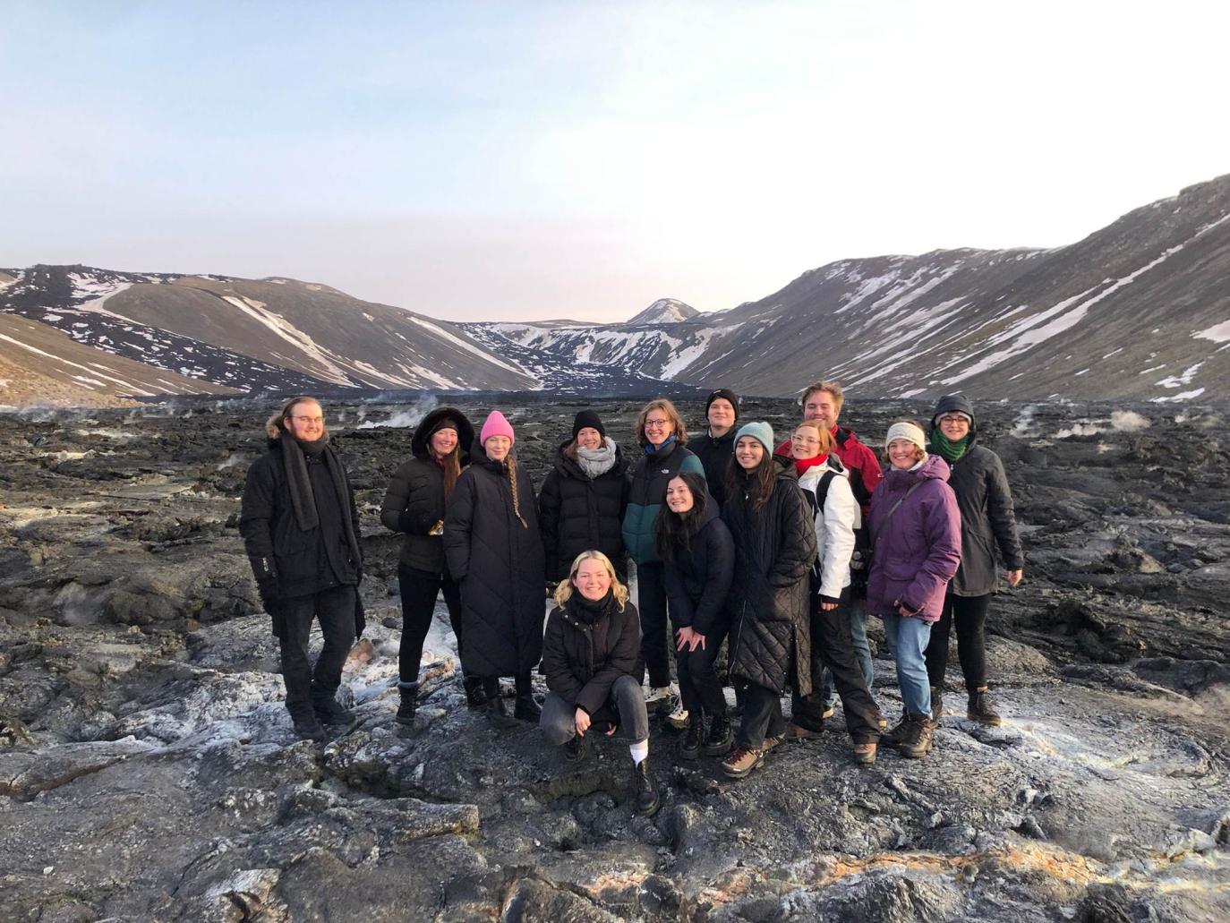 Hópur af ungu fólki með fjöll í baksýn