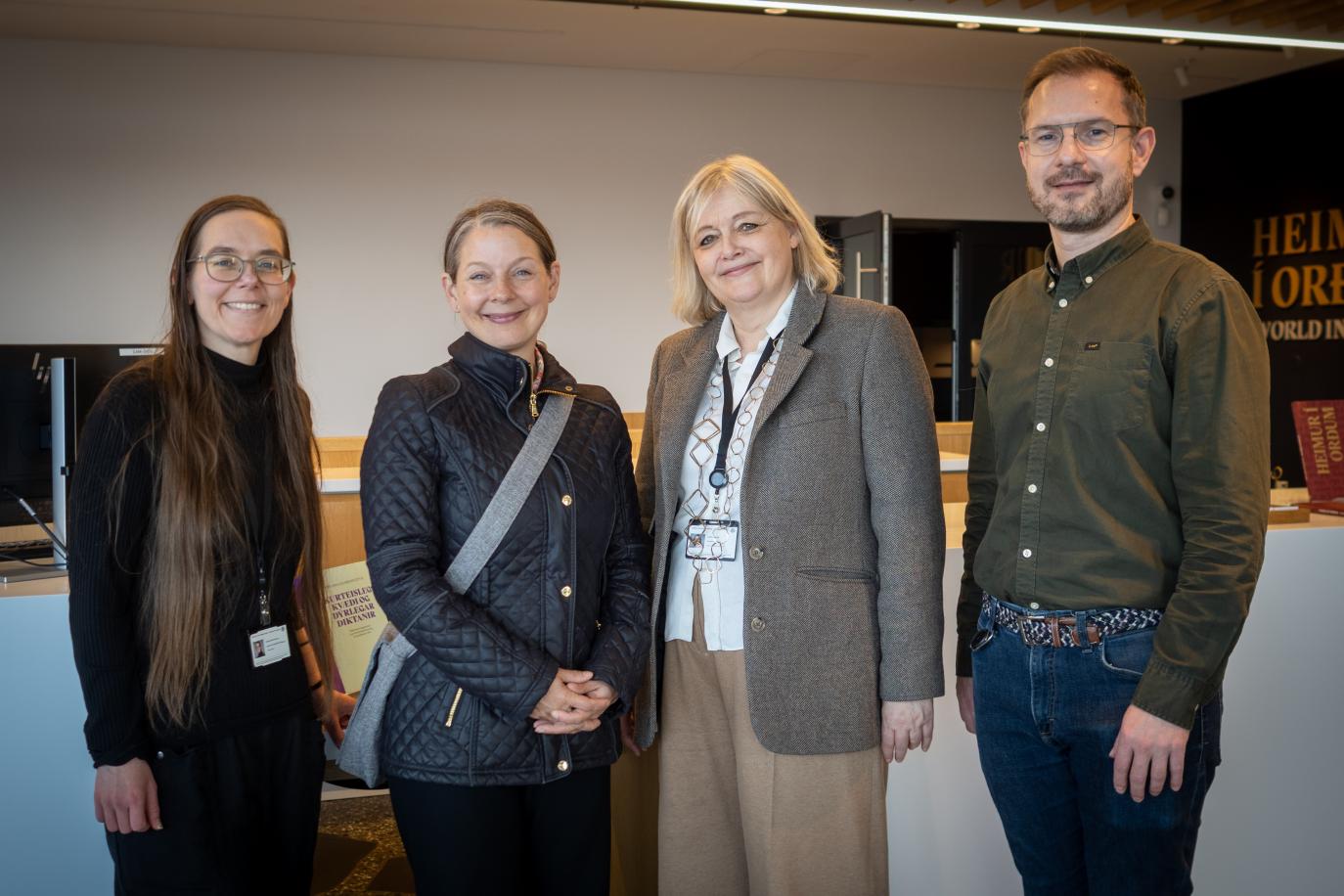 fjórar manneskjur standa saman